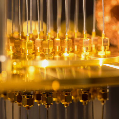 Close-up of a quantum computer's golden connectors and wiring.
